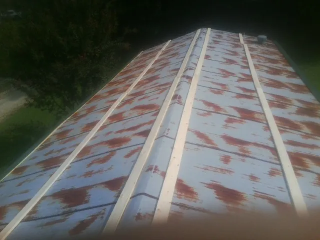 Rusted metal roof panels with new wood purlins before replacement — Storm Damage Roof Repair in Allison by Roofing Brothers