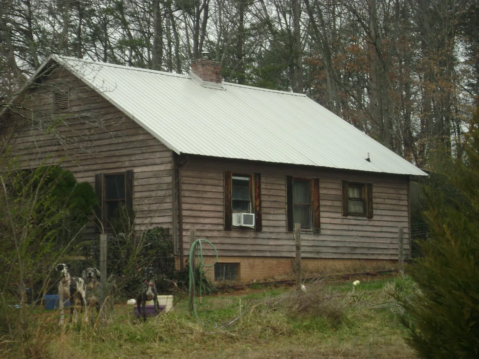 White metal roof on an old wood sided farmhouse, from a Metal Roof Installation job in Allison